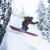 Freeride skier standing over powder field with yellow and purple powder and freeride Faction Studio 3 ski 2026